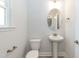 Clean half bathroom features a pedestal sink, oval mirror, and a neutral color scheme at 138 New Twin Branch Ct, Smithfield, NC 27577