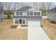 Aerial view of a two-story home with gray siding, a two-car garage, and an expansive driveway at 138 New Twin Branch Ct, Smithfield, NC 27577