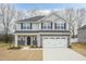 Charming two-story home boasts stone accents, a two-car garage, and a well-manicured front lawn at 138 New Twin Branch Ct, Smithfield, NC 27577