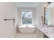 Elegant bathroom featuring a soaking tub, a large window, and neutral tones at 600 N Roxboro St # 24, Durham, NC 27701