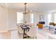 Bright dining room with modern light fixture, table set for six, and open concept living area with fireplace at 600 N Roxboro St # 24, Durham, NC 27701