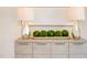 Close up of dresser with decorative lamps, green moss orbs, and textured abstract art piece at 600 N Roxboro St # 24, Durham, NC 27701