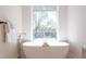 Luxurious bathroom with a standalone soaking tub and a view of nature through a large window at 600 N Roxboro St # 43, Durham, NC 27701