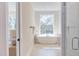 Luxurious bathroom showcasing a freestanding tub beneath a large window, complemented by elegant tile and fixtures at 600 N Roxboro St # 43, Durham, NC 27701