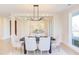 Bright dining room with a modern light fixture, seating for six, and views of the city skyline through large windows at 600 N Roxboro St # 43, Durham, NC 27701