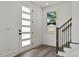 Bright entryway features a modern door with glass panels, staircase with dark railings, and wood flooring at 2329 E Main St, Durham, NC 27703