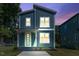 Well-lit two-story home with modern exterior, a covered porch, and a manicured lawn at dusk at 2329 E Main St, Durham, NC 27703