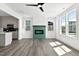 Open-concept living room featuring a tile fireplace, wood floors, and an adjacent kitchen area at 2329 E Main St, Durham, NC 27703