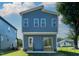 A backyard view of a home featuring blue siding, a covered patio, and multiple windows at 2329 E Main St, Durham, NC 27703