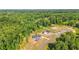 Expansive aerial view showcases a modern home with a long driveway nestled in a lush, green, wooded area at 4268 Jacks Creek Trl, Burlington, NC 27215