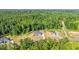 An aerial view of the property in a wooded neighborhood in summer with blue skies at 4268 Jacks Creek Trl, Burlington, NC 27215