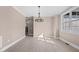 Dining room features a modern chandelier, neutral paint, white trim, and large windows providing natural light at 4268 Jacks Creek Trl, Burlington, NC 27215