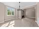 Bright dining room with a large window, modern chandelier, neutral paint, white trim, and light hardwood floors at 4268 Jacks Creek Trl, Burlington, NC 27215