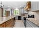 A spacious kitchen boasts gray cabinets, granite countertops, and a central island with wood cabinets at 4268 Jacks Creek Trl, Burlington, NC 27215