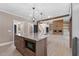 Open-concept living space with kitchen island, wood floors, and brick fireplace at 4268 Jacks Creek Trl, Burlington, NC 27215