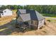 Rear corner view of the home featuring a covered back porch, gray siding and black framed windows at 4268 Jacks Creek Trl, Burlington, NC 27215