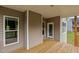 Spacious back porch with natural wood decking and white trim around the windows at 75 Woodbark Cv # 10, Willow Springs, NC 27592