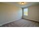 A bright, carpeted bedroom features a window providing natural light, creating a cozy and inviting atmosphere at 492 Traditions Grande Blvd # 26, Wake Forest, NC 27587