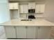 A kitchen island with stainless steel sink, white cabinets, and granite countertops at 492 Traditions Grande Blvd # 26, Wake Forest, NC 27587