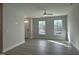 Bright living room features neutral walls, wood floors, ceiling fan, and natural light from large windows at 492 Traditions Grande Blvd # 26, Wake Forest, NC 27587