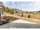 View of the large backyard showcasing green and brown grass, shrubs, and gray home at 804 Ambercrest Place, Durham, NC 27705