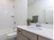 Bathroom with shower-tub combo, white tile, and a vanity with gray cabinets at 804 Ambercrest Place, Durham, NC 27705