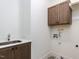 This laundry room features tile floors, a stainless steel sink and upper cabinets at 804 Ambercrest Place, Durham, NC 27705