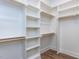 This walk-in closet features white walls, wood-look floors, and custom shelving with wooden rods at 804 Ambercrest Place, Durham, NC 27705