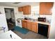 Kitchen featuring wooden cabinets, white appliances, and a stainless steel sink with a view to the dining room at 2913 Wadsworth Ave, Durham, NC 27707