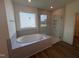 Bright bathroom features a garden tub and glass shower at 103 Sage Ln # 009, Four Oaks, NC 27524
