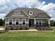 Charming single-Gathering home featuring stone accents, well-manicured lawn, and inviting front porch at 103 Sage Ln # 009, Four Oaks, NC 27524