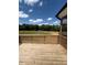 Wooden back deck with a view of a large backyard and tree line at 123 Sage Ln # 010, Four Oaks, NC 27524