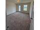 Neutral bedroom with carpet, window, and access to the back door at 123 Sage Ln # 010, Four Oaks, NC 27524