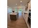 Open-concept kitchen with granite island, modern appliances, and an adjoining living area at 123 Sage Ln # 010, Four Oaks, NC 27524