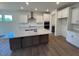 Well-lit kitchen with large granite island, stainless steel appliances, and ample cabinet space at 123 Sage Ln # 010, Four Oaks, NC 27524
