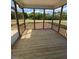 Screened porch with wooden floors and railing with a view of trees in the backyard at 123 Sage Ln # 010, Four Oaks, NC 27524