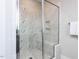 Beautiful walk-in shower with marble tiling, a glass door, built in bench, and a shower niche at 6059 Scalybark Road, Durham, NC 27712