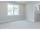 Bedroom features carpet flooring, a large window and an open doorway to the closet at 6059 Scalybark Road, Durham, NC 27712