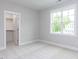 Carpeted bedroom with natural light and view from window to the backyard and access to closet space at 6059 Scalybark Road, Durham, NC 27712