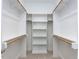 Spacious walk-in closet featuring white shelving and wood closet rods at 6059 Scalybark Road, Durham, NC 27712