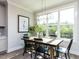 Bright dining room with a rustic table, black chairs, and large windows at 6059 Scalybark Road, Durham, NC 27712