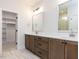Bathroom with double vanity, large mirrors and access to closet at 6060 Scalybark Rd, Durham, NC 27712