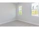 Clean bedroom with neutral carpet and two large windows at 6060 Scalybark Rd, Durham, NC 27712