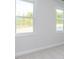 Bedroom with two large windows, neutral carpeting, and fresh paint at 6060 Scalybark Rd, Durham, NC 27712