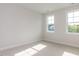 Clean, neutral bedroom with ample natural light from two large windows at 6060 Scalybark Rd, Durham, NC 27712