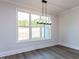 Bright dining room with large windows and modern light fixture at 6060 Scalybark Rd, Durham, NC 27712