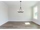 Empty dining room with beautiful flooring, a statement chandelier, and natural light at 6060 Scalybark Rd, Durham, NC 27712