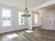 An open dining room featuring beautiful flooring and a modern chandelier at 6060 Scalybark Rd, Durham, NC 27712