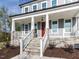 Inviting front porch with stone accents, white railings, and a vibrant red door at 6060 Scalybark Rd, Durham, NC 27712