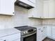 Close up of stainless steel oven and white cabinets with tile backsplash and countertops at 6060 Scalybark Rd, Durham, NC 27712
